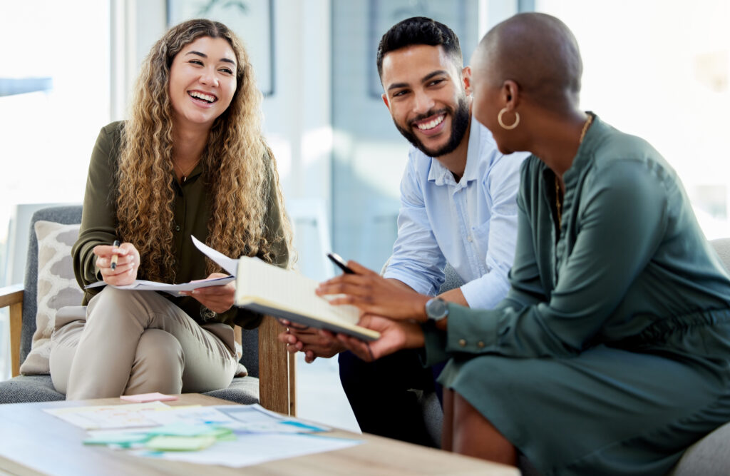 Happy Business People Smile During A Planning Meeting In A Startup Marketing Agency Office. Diversity, Collaboration And Teamwork In A Healthy Work Environment In An International Advertising Company
