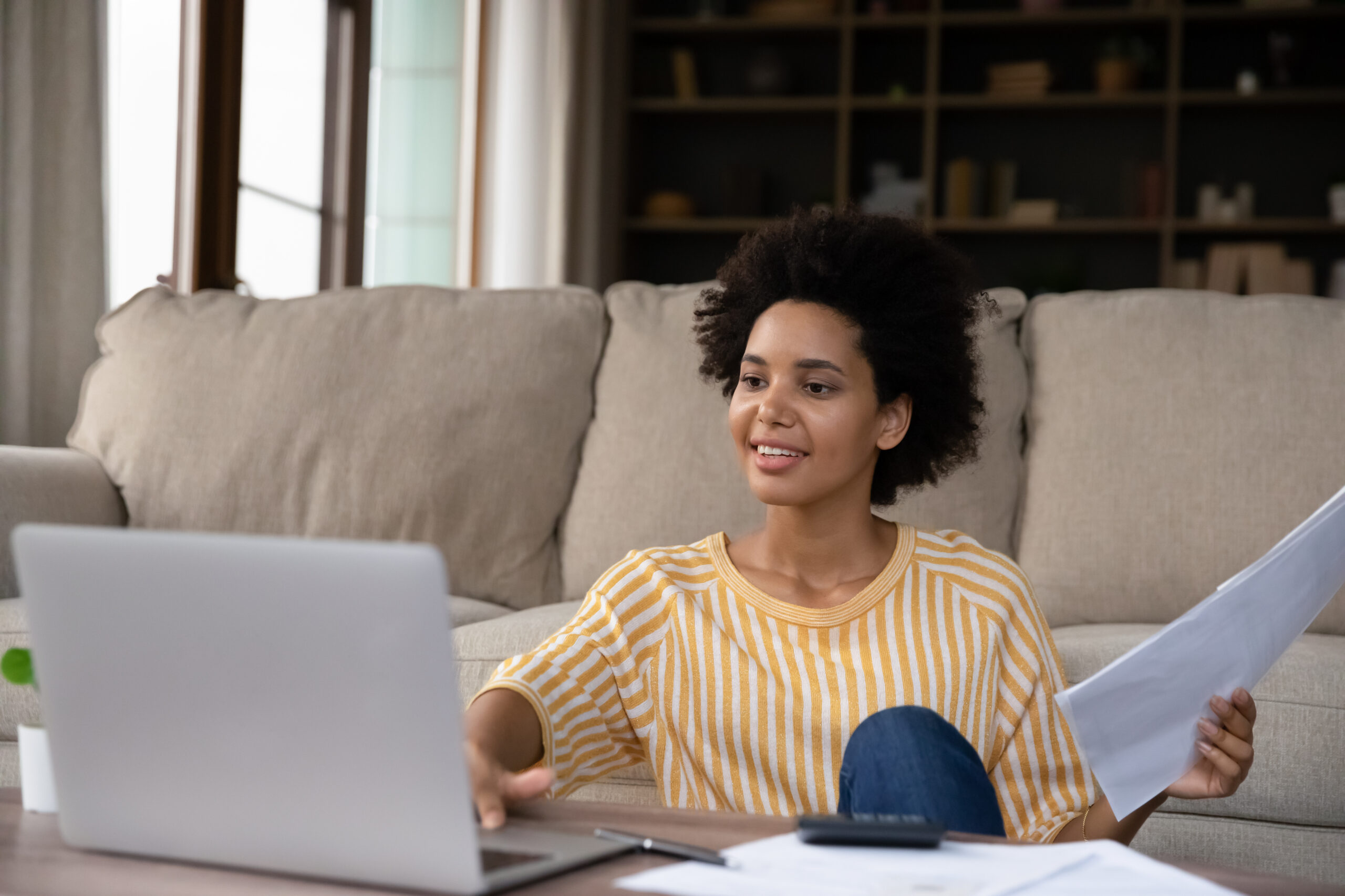 Happy Young Black Woman Counting Budget At Home, Checking Bills